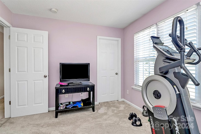 workout room with light carpet and a textured ceiling