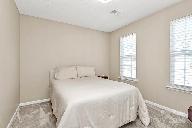 carpeted bedroom with a textured ceiling