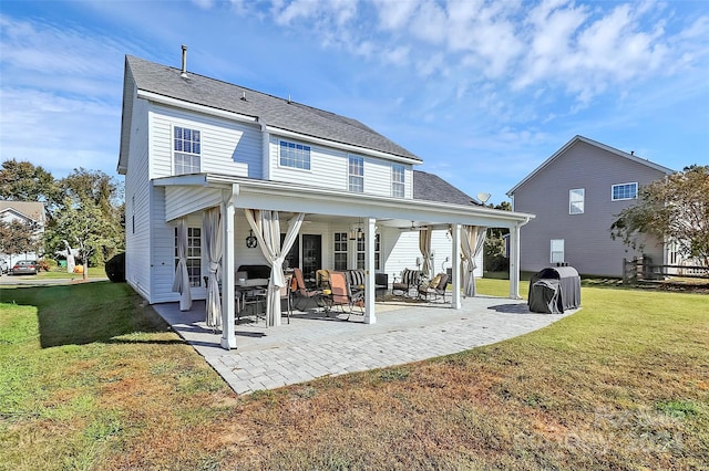 rear view of house featuring a yard, a patio area, and ceiling fan