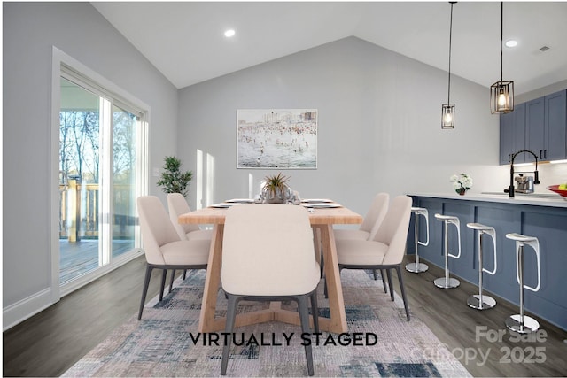 dining space with vaulted ceiling, sink, and dark wood-type flooring