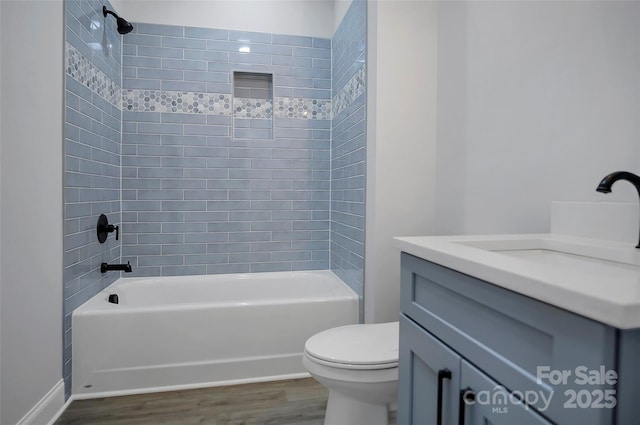 bathroom with toilet, bathing tub / shower combination, wood finished floors, and vanity