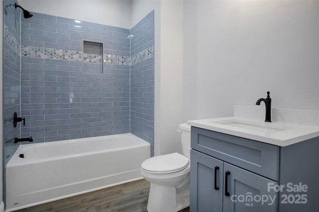 full bath with shower / bathtub combination, vanity, wood finished floors, and toilet