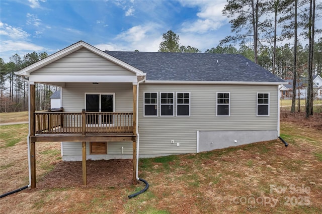 rear view of property featuring a shingled roof and a deck