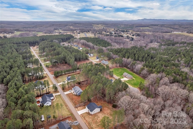 birds eye view of property featuring a wooded view