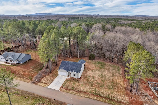 drone / aerial view featuring a wooded view