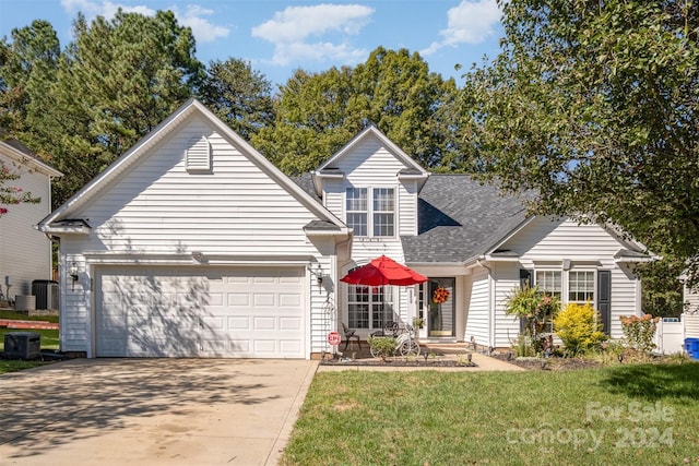 traditional-style house with a shingled roof, a front lawn, central air condition unit, concrete driveway, and a garage