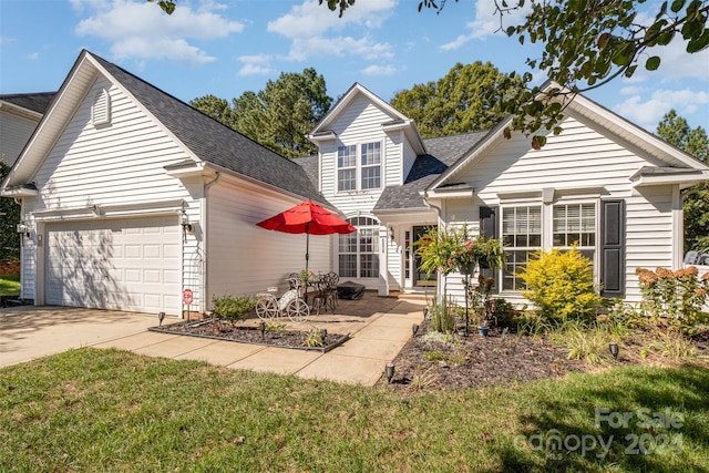traditional home featuring a garage, driveway, and a shingled roof