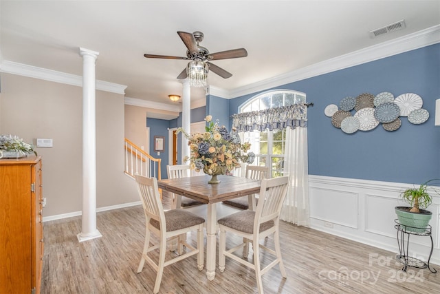 dining area featuring visible vents, light wood-style floors, ornate columns, a ceiling fan, and crown molding