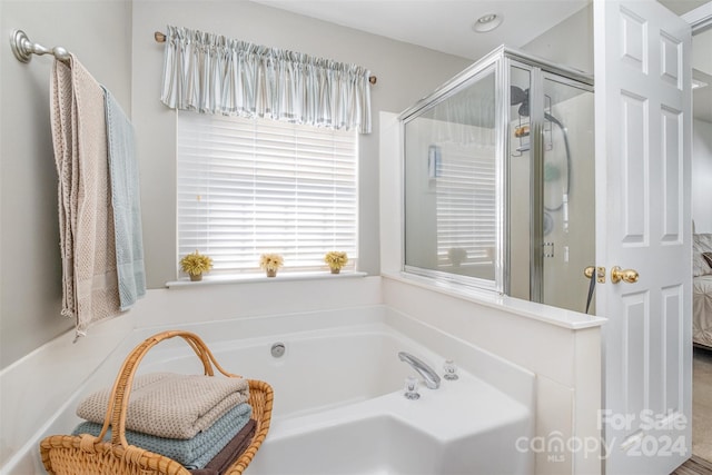 bathroom featuring shower with separate bathtub