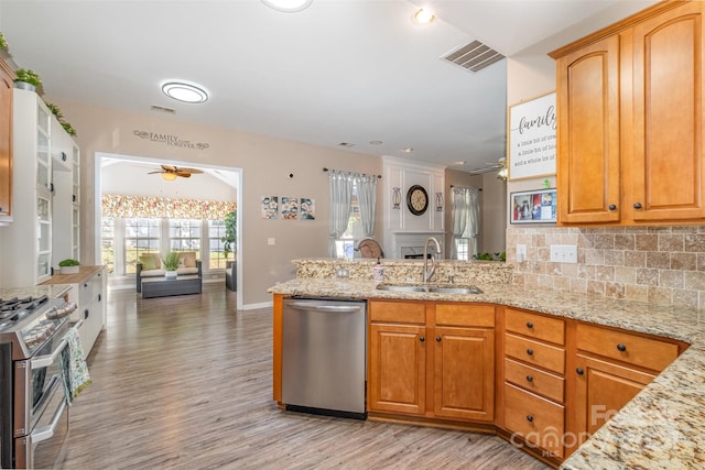 kitchen with decorative backsplash, ceiling fan, sink, light hardwood / wood-style floors, and stainless steel appliances