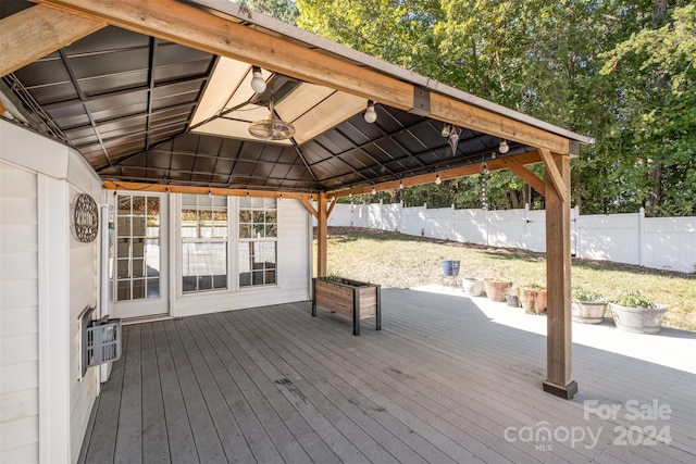 wooden terrace with a gazebo and fence