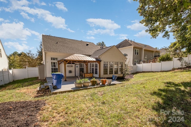 rear view of property featuring a fenced backyard, a yard, roof with shingles, a patio area, and a gazebo