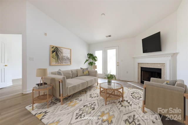 living room with high vaulted ceiling and light hardwood / wood-style floors