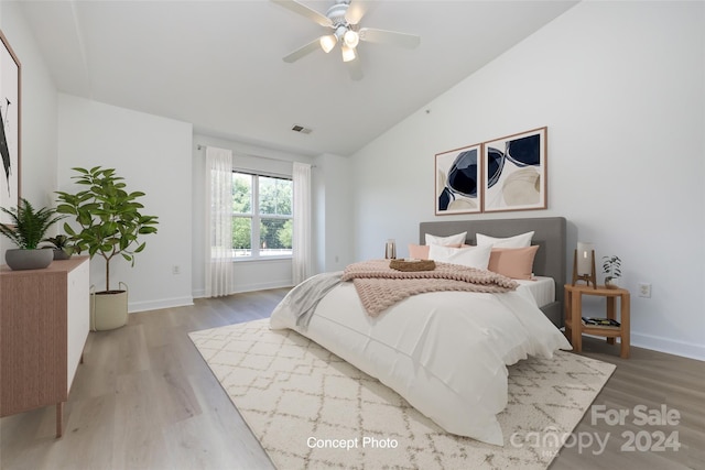 bedroom with ceiling fan, hardwood / wood-style flooring, and lofted ceiling