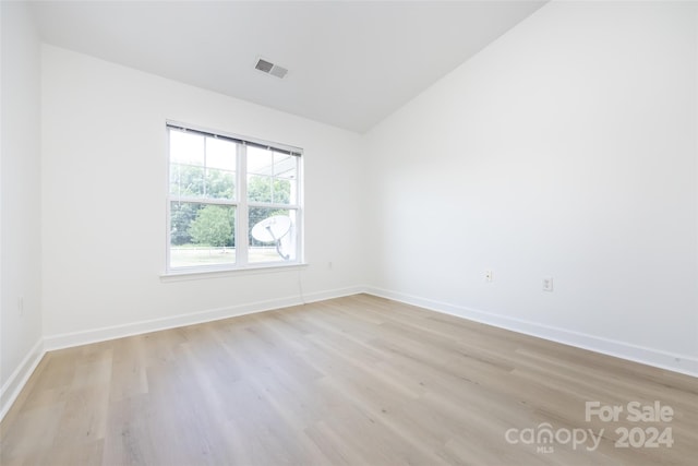 unfurnished room with lofted ceiling and light hardwood / wood-style flooring