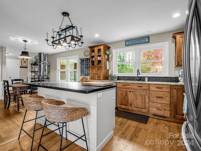 kitchen featuring a breakfast bar area, a center island, light hardwood / wood-style flooring, and sink