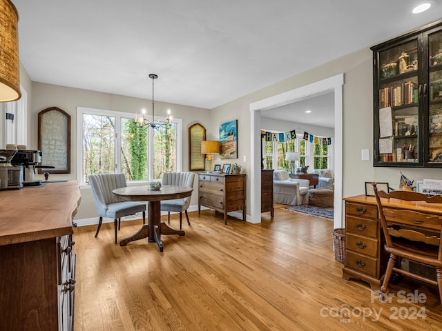 dining room featuring a notable chandelier, plenty of natural light, and light hardwood / wood-style flooring