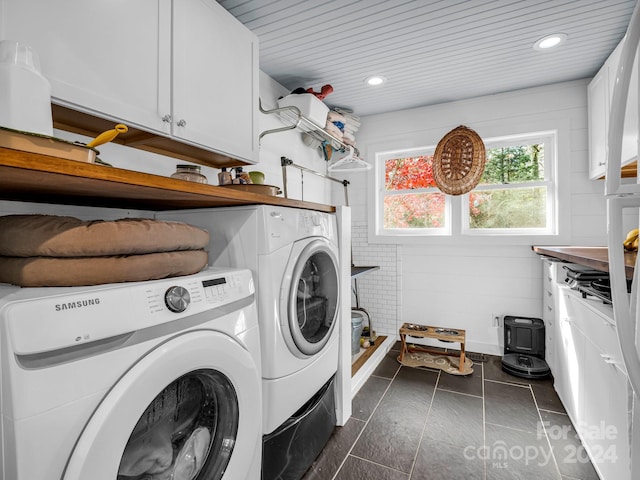 laundry room featuring cabinets, washing machine and dryer, dark tile patterned floors, and wood ceiling