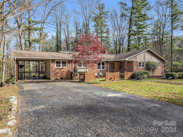 ranch-style home featuring a front lawn and a carport