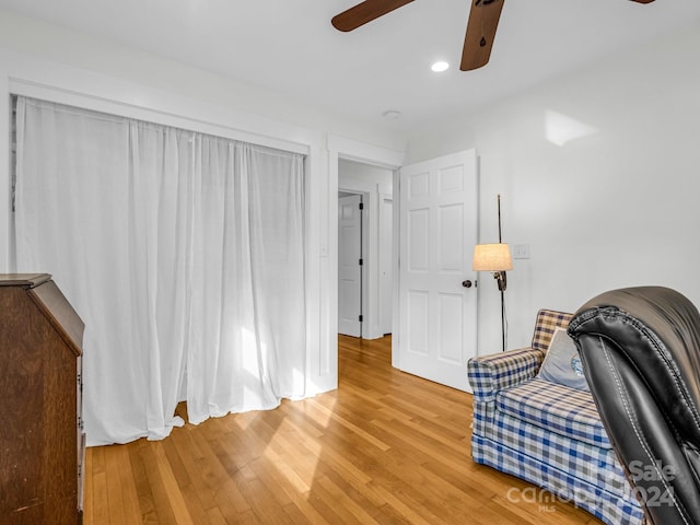 sitting room with hardwood / wood-style flooring and ceiling fan