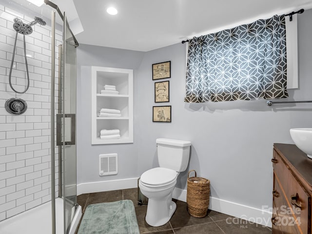 bathroom featuring built in shelves, tile patterned flooring, an enclosed shower, toilet, and vanity