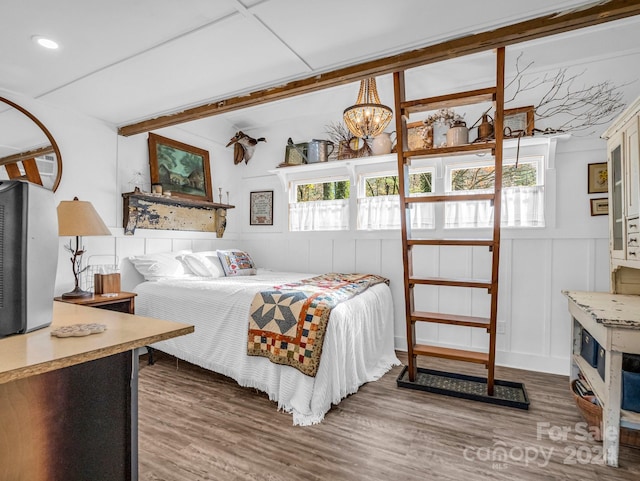 bedroom with dark hardwood / wood-style floors and an inviting chandelier