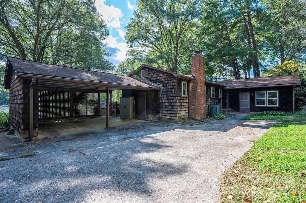 view of front facade featuring central AC and a carport