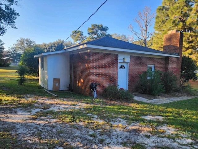view of property exterior featuring a chimney and brick siding