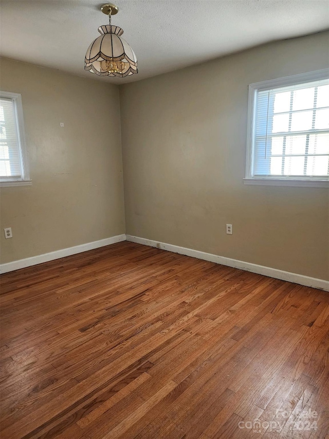 unfurnished room with baseboards and wood finished floors
