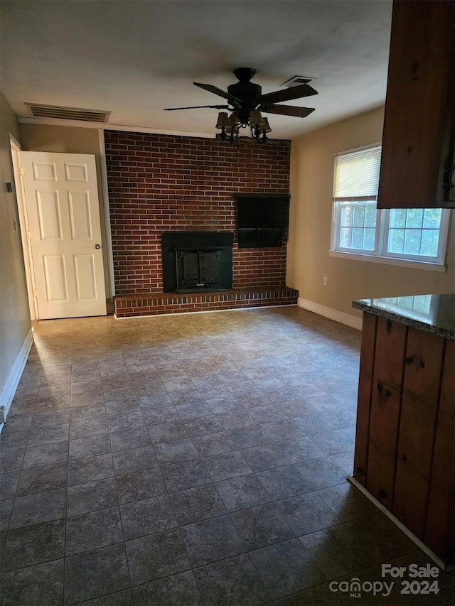 unfurnished living room featuring visible vents, baseboards, a fireplace, and ceiling fan