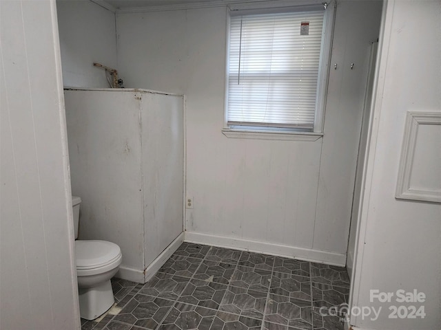 bathroom featuring baseboards, toilet, and tile patterned floors