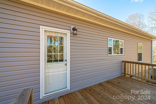 view of exterior entry with a wooden deck