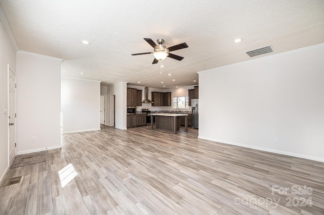 unfurnished living room with ornamental molding, a textured ceiling, and light wood-type flooring