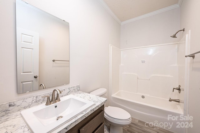 full bathroom featuring vanity, bathing tub / shower combination, toilet, ornamental molding, and a textured ceiling