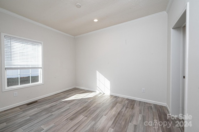 interior space with ornamental molding, a textured ceiling, and light wood-type flooring