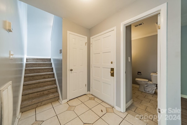 foyer entrance featuring ornamental molding and light tile patterned floors