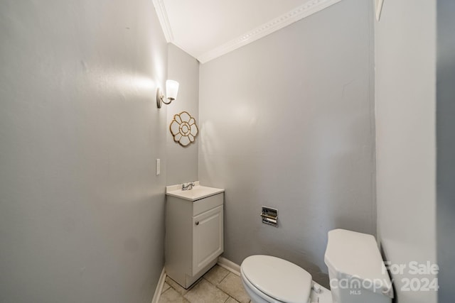 bathroom with vanity, ornamental molding, toilet, and tile patterned flooring