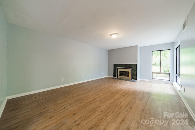 unfurnished living room with hardwood / wood-style floors and a tile fireplace