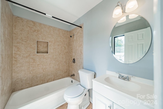 full bathroom featuring toilet, a notable chandelier, tiled shower / bath combo, and vanity