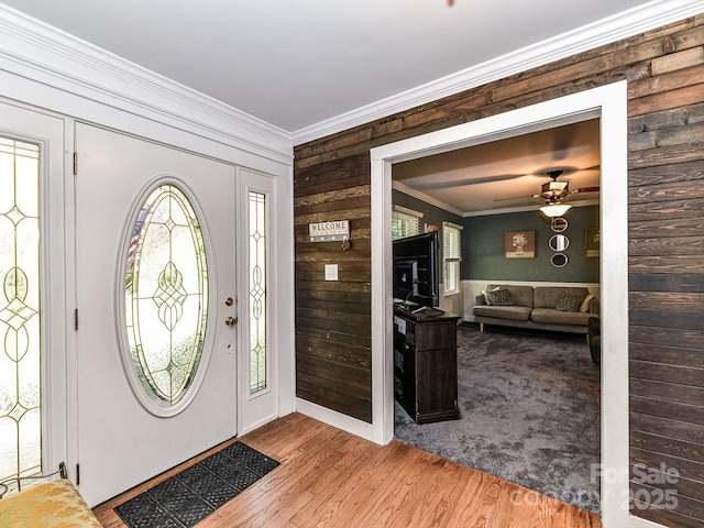 entrance foyer with ceiling fan, crown molding, and light hardwood / wood-style floors