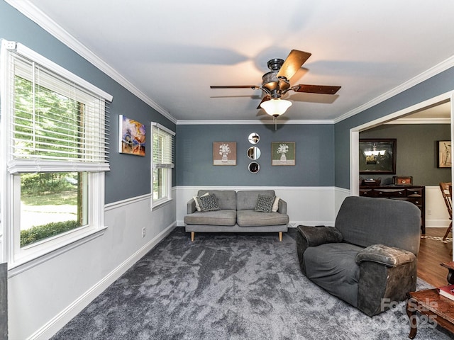 carpeted living room featuring ceiling fan, crown molding, and plenty of natural light