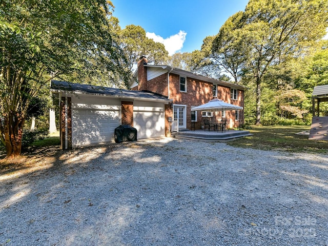 view of front of house featuring a garage and an outbuilding