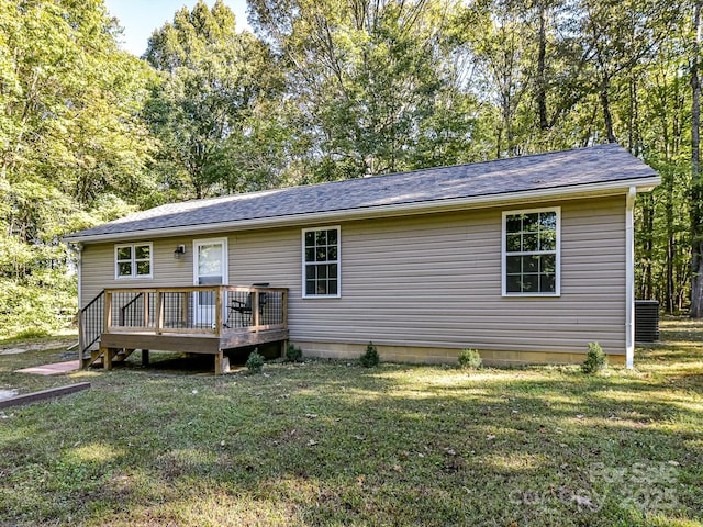 rear view of property featuring a lawn and a deck