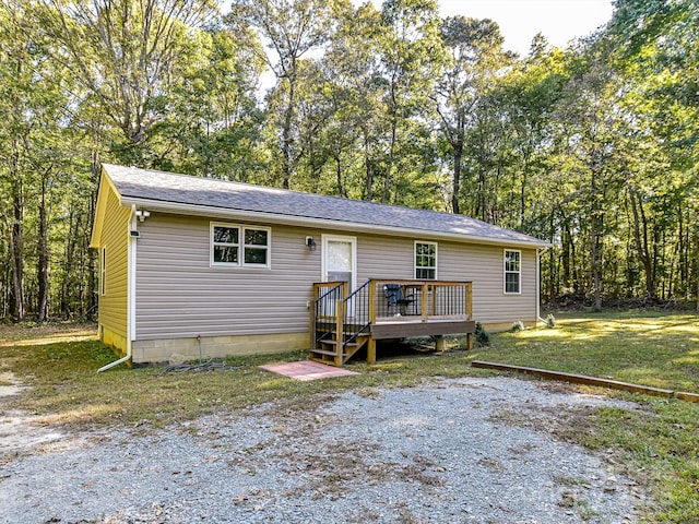 view of front of house with a wooden deck and a front yard