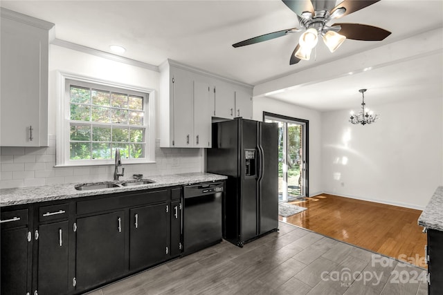 kitchen featuring black appliances, white cabinets, light hardwood / wood-style flooring, and decorative light fixtures