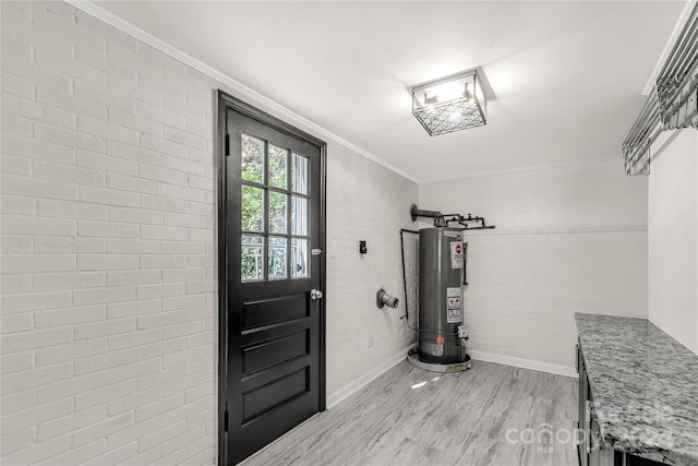 interior space with brick wall, water heater, crown molding, and light hardwood / wood-style floors