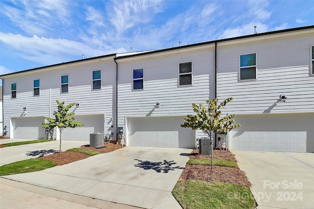 townhome / multi-family property featuring central AC and a garage