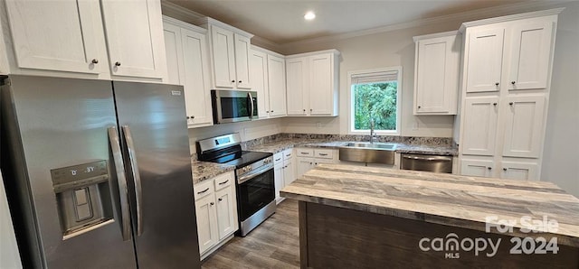 kitchen featuring white cabinets, crown molding, sink, light stone counters, and stainless steel appliances