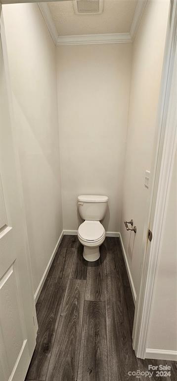 bathroom featuring crown molding, toilet, and hardwood / wood-style flooring