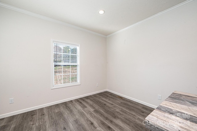 empty room featuring dark hardwood / wood-style flooring and ornamental molding